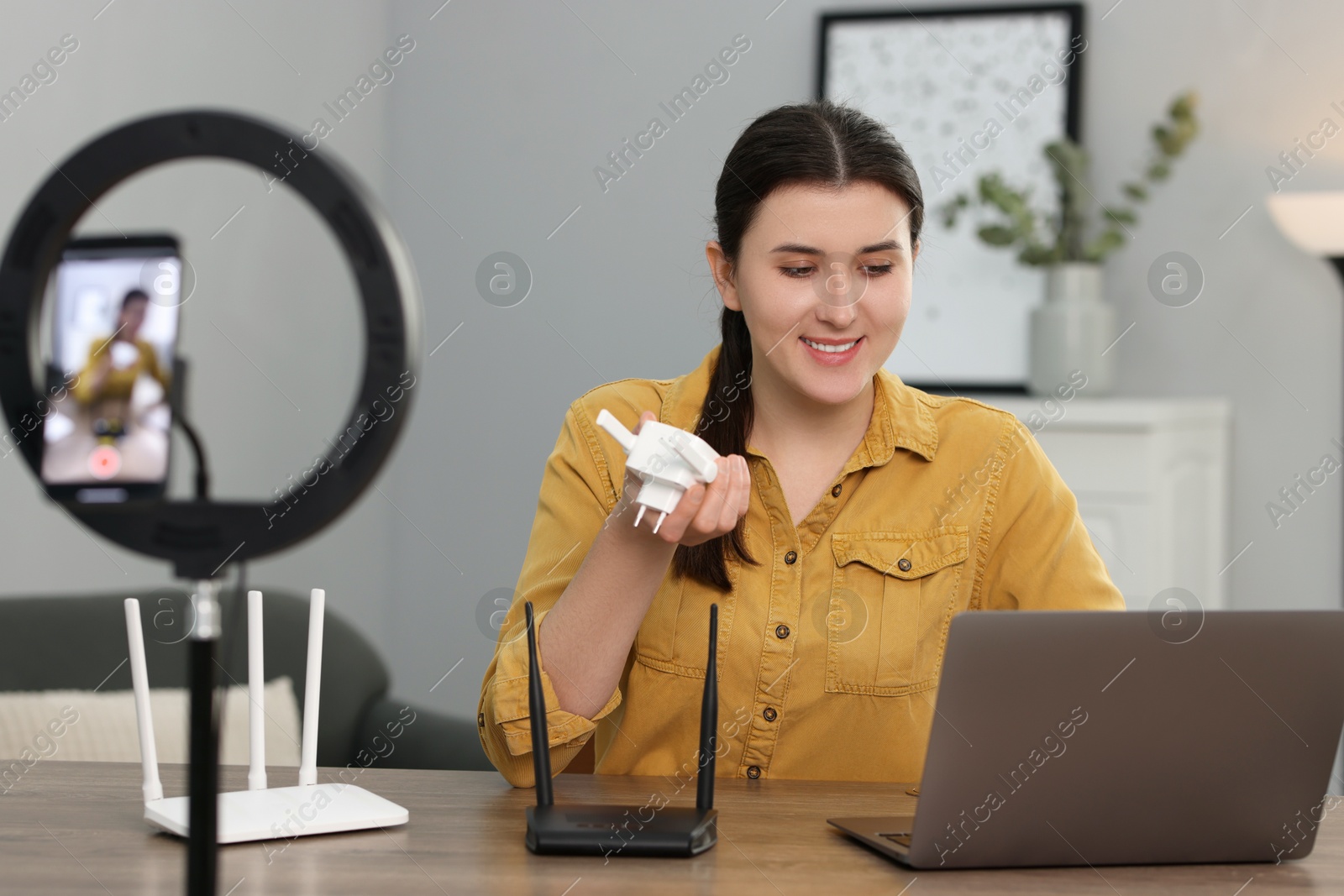 Photo of Smiling technology blogger recording video review about WI-FI devices at home