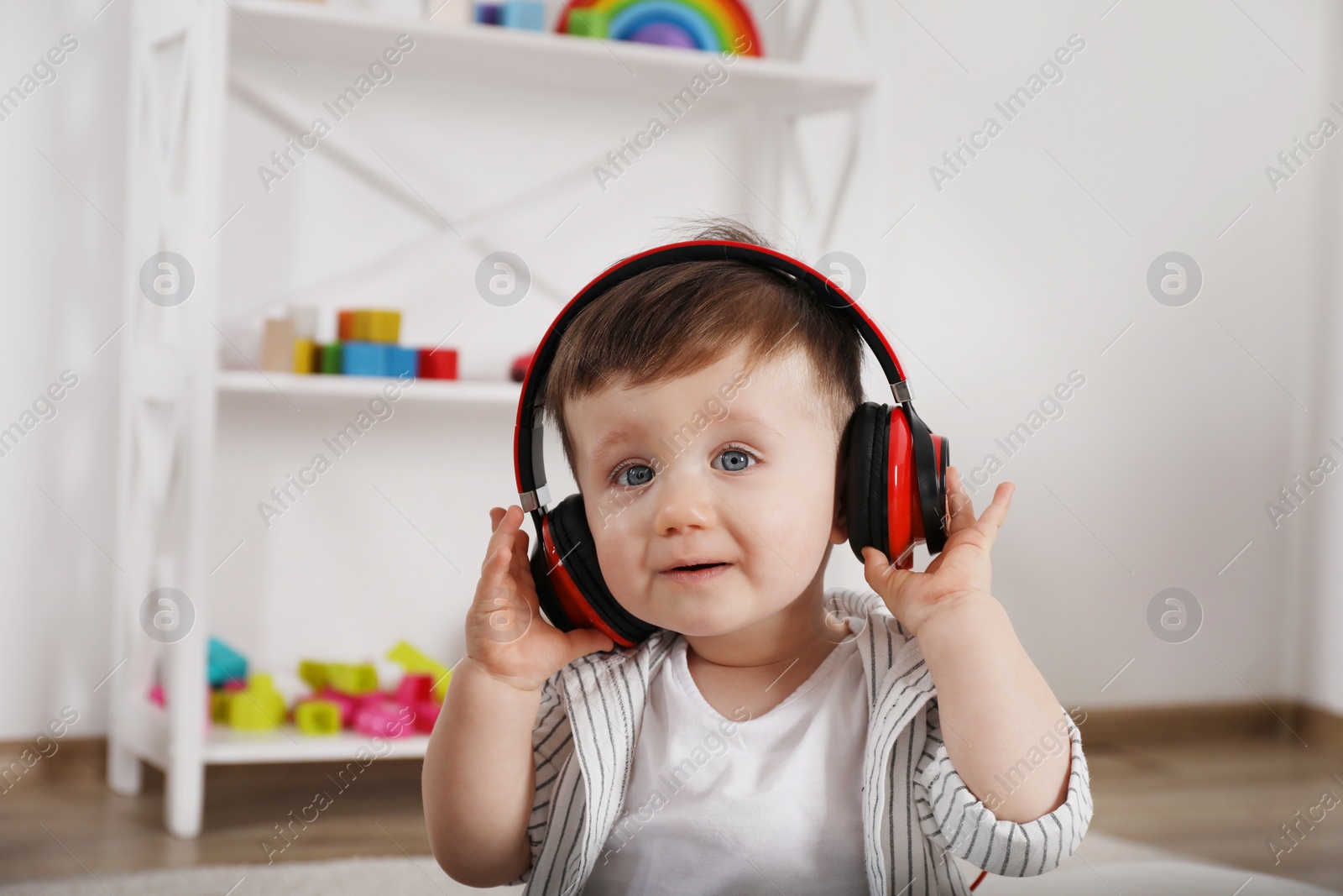 Photo of Cute little boy in headphones listening to music at home