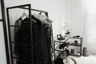 Photo of Rack with stylish women's clothes, shoes and accessories in dressing room