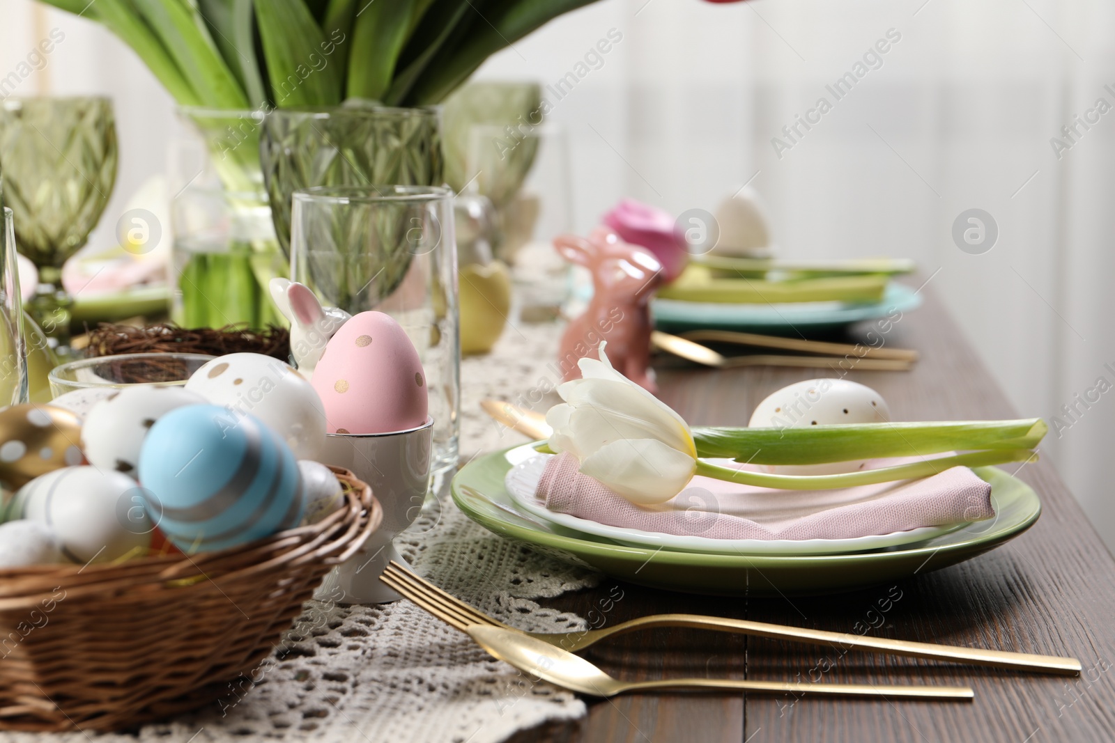 Photo of Festive table setting with painted eggs. Easter celebration