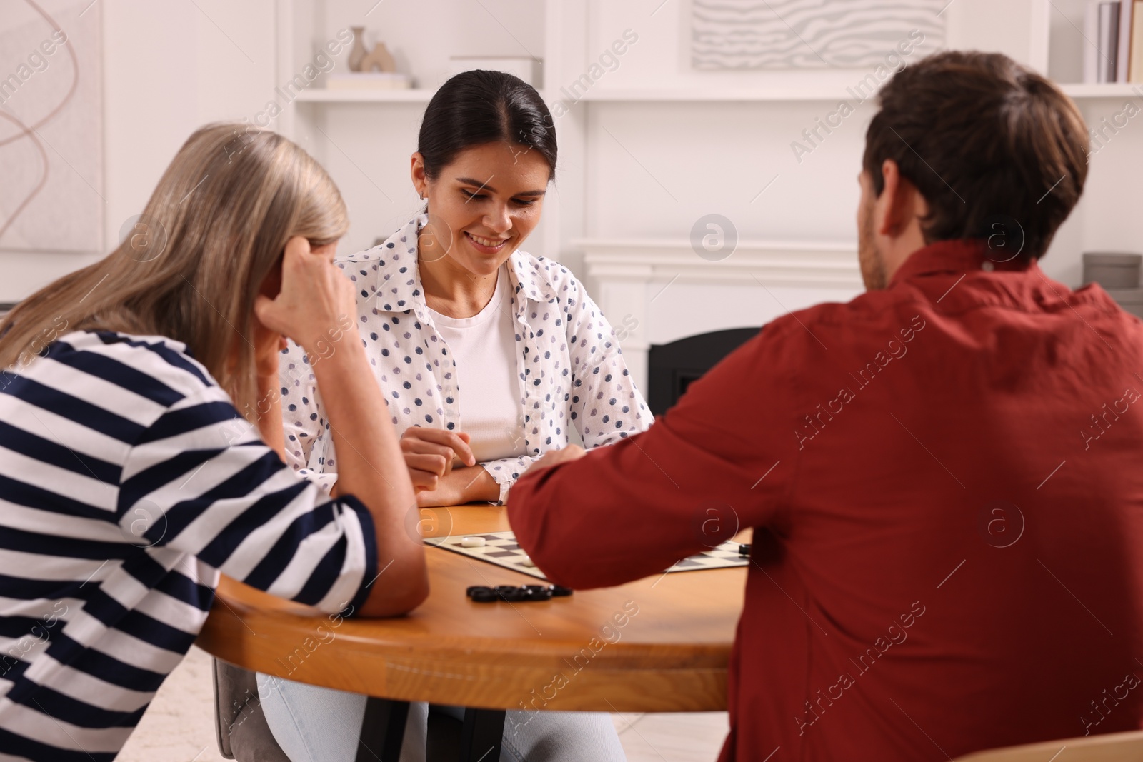 Photo of Family playing checkers at coffee table in room