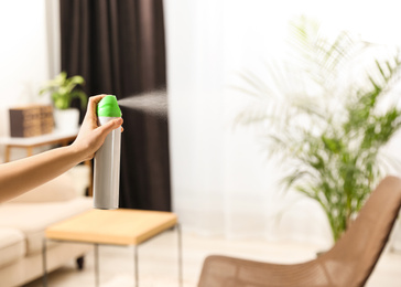 Photo of Woman spraying air freshener at home, closeup