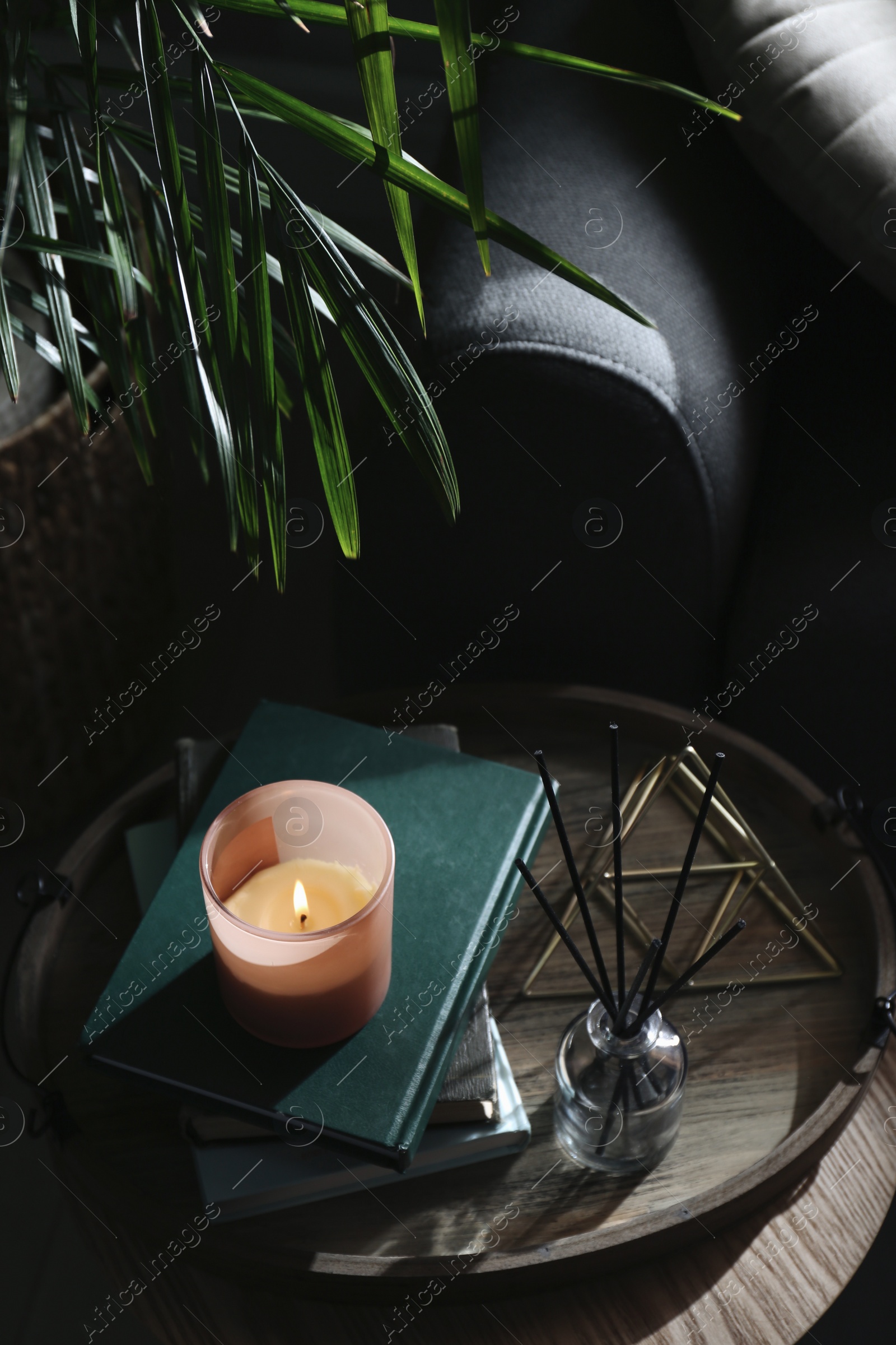 Photo of Wooden tray with decorations and books on table in room