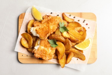 Photo of British traditional fish and potato chips on table, top view