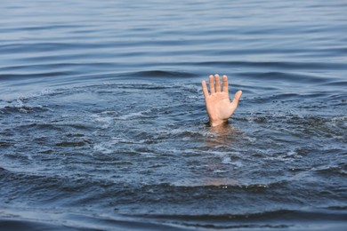 Drowning man reaching for help in sea, closeup