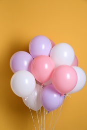 Photo of Different helium party balloons on color background