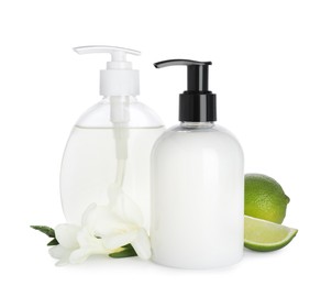 Photo of Dispensers with liquid soap, freesia flowers and limes on white background