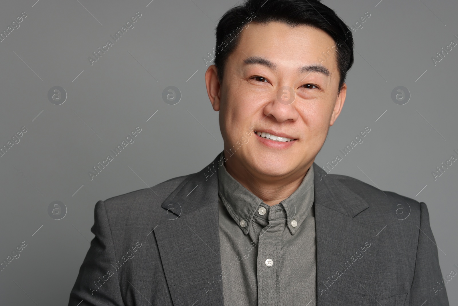 Photo of Portrait of happy businessman on grey background
