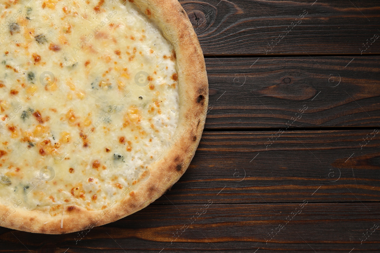 Photo of Delicious cheese pizza on wooden table, top view. Space for text