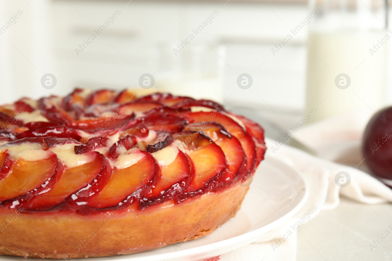 Photo of Delicious cake with plums on plate, closeup