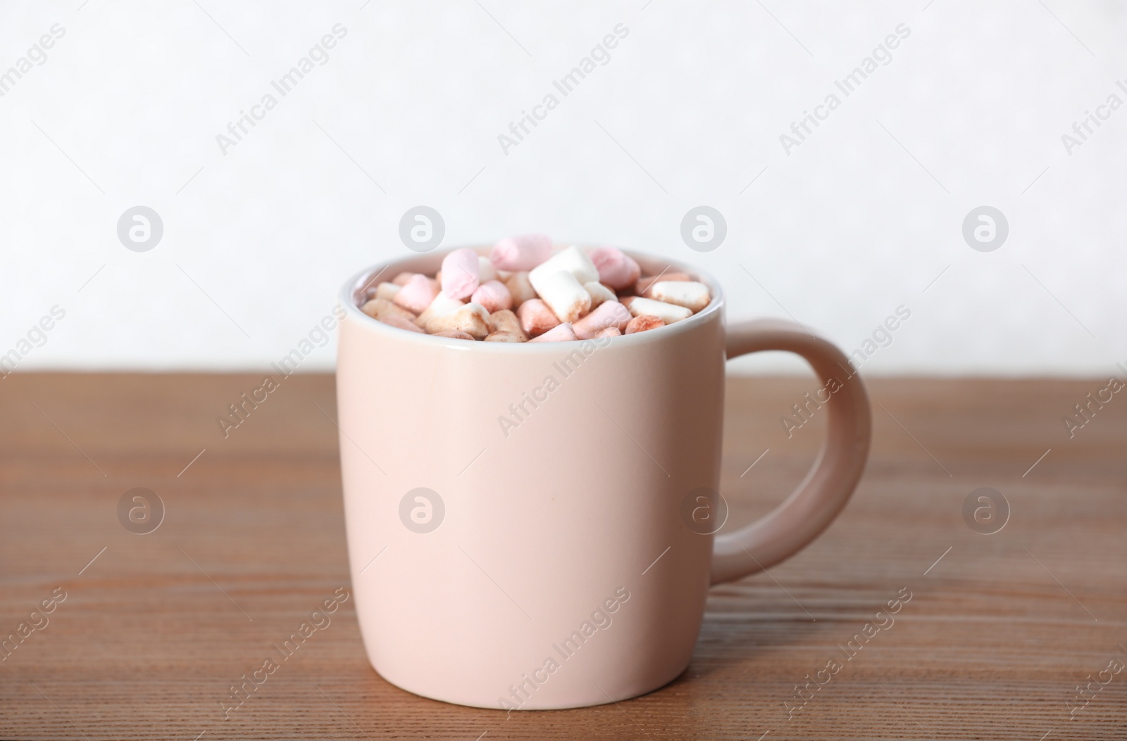 Photo of Cup of aromatic cacao with marshmallows on wooden table