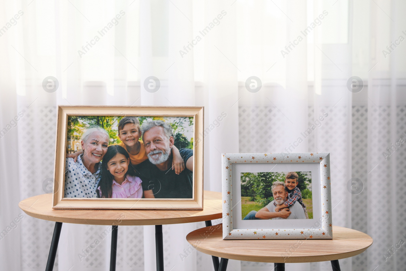 Photo of Framed family portraits near window in room