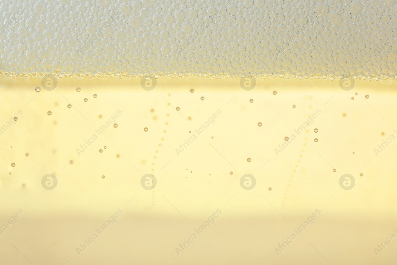 Photo of Closeup view of champagne with bubbles as background