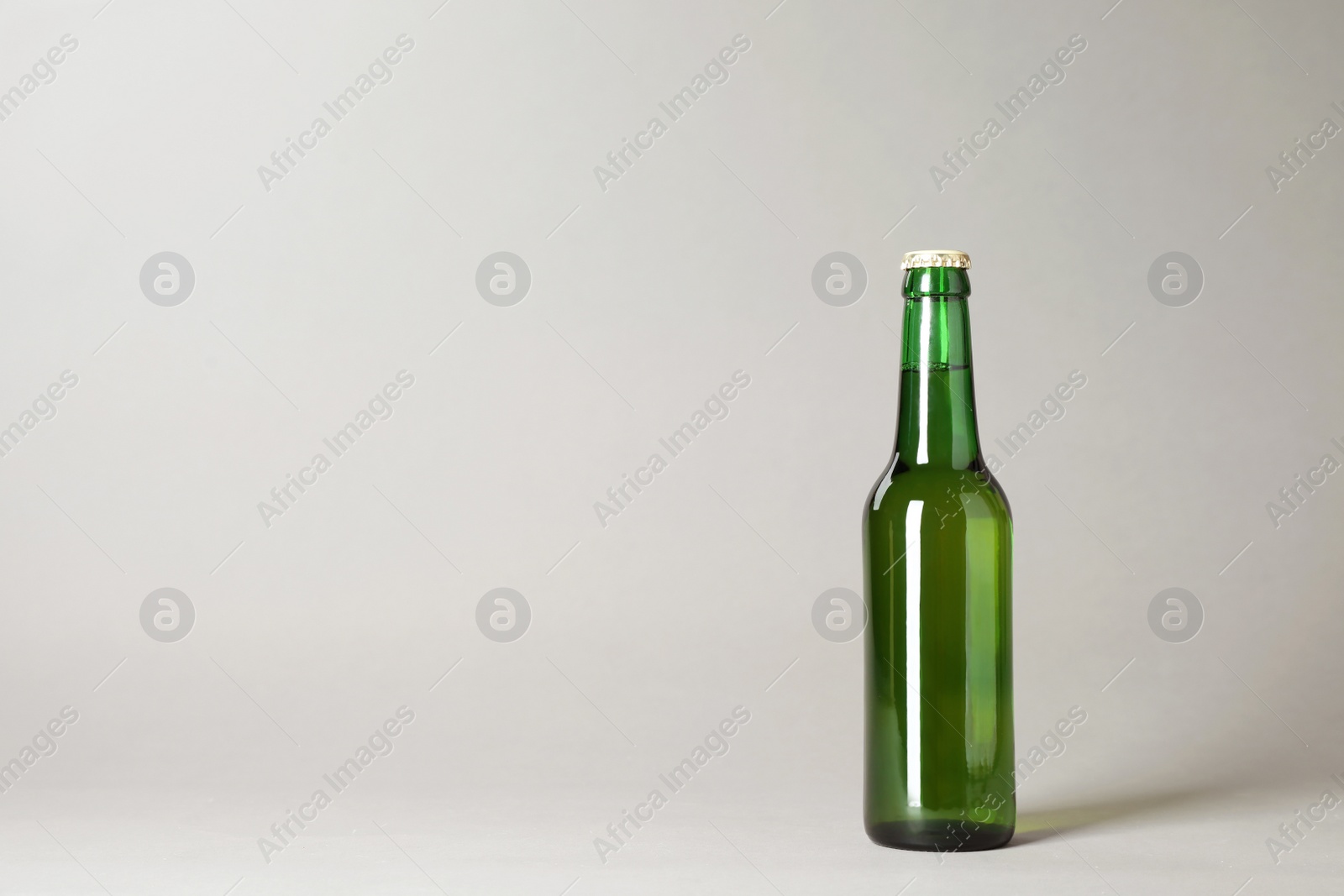 Photo of Bottle of beer on grey background. Space for text