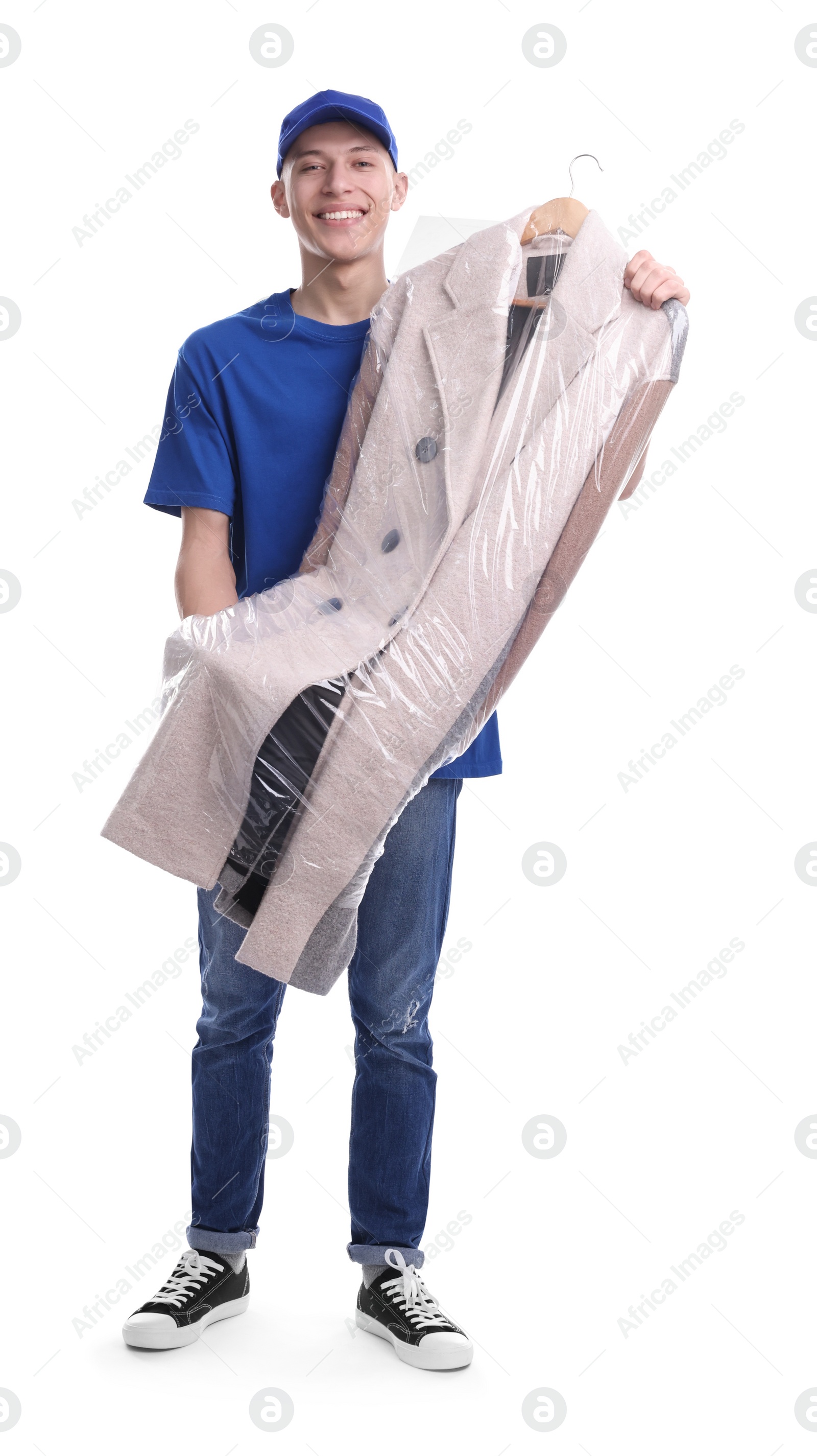 Photo of Dry-cleaning delivery. Happy courier holding coat in plastic bag on white background