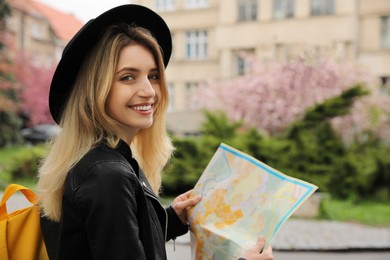 Photo of Beautiful young tourist with map on city street