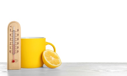 Photo of Thermometer, lemon and cup of hot tea on wooden table against white background. Space for text
