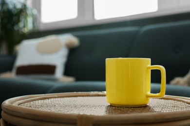 Ceramic mug on wicker table indoors. Mockup for design