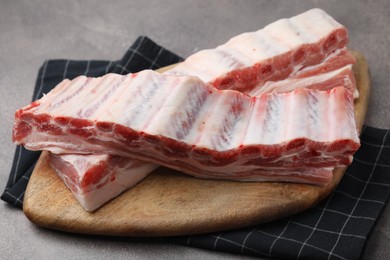 Photo of Fresh raw pork ribs on grey table, closeup