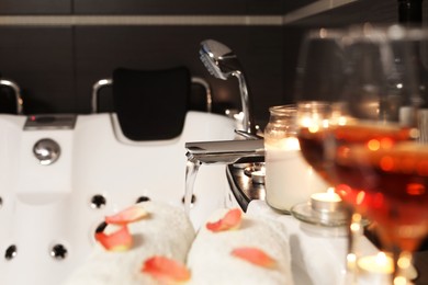Photo of Candles and towels on tub in bathroom, space for text. Romantic atmosphere