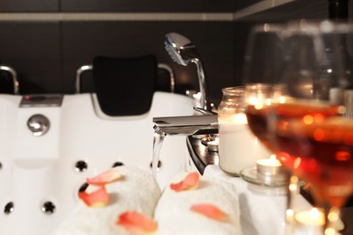 Candles and towels on tub in bathroom, space for text. Romantic atmosphere