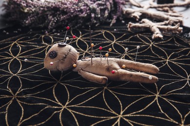 Photo of Voodoo doll pierced with pins on table. Curse ceremony