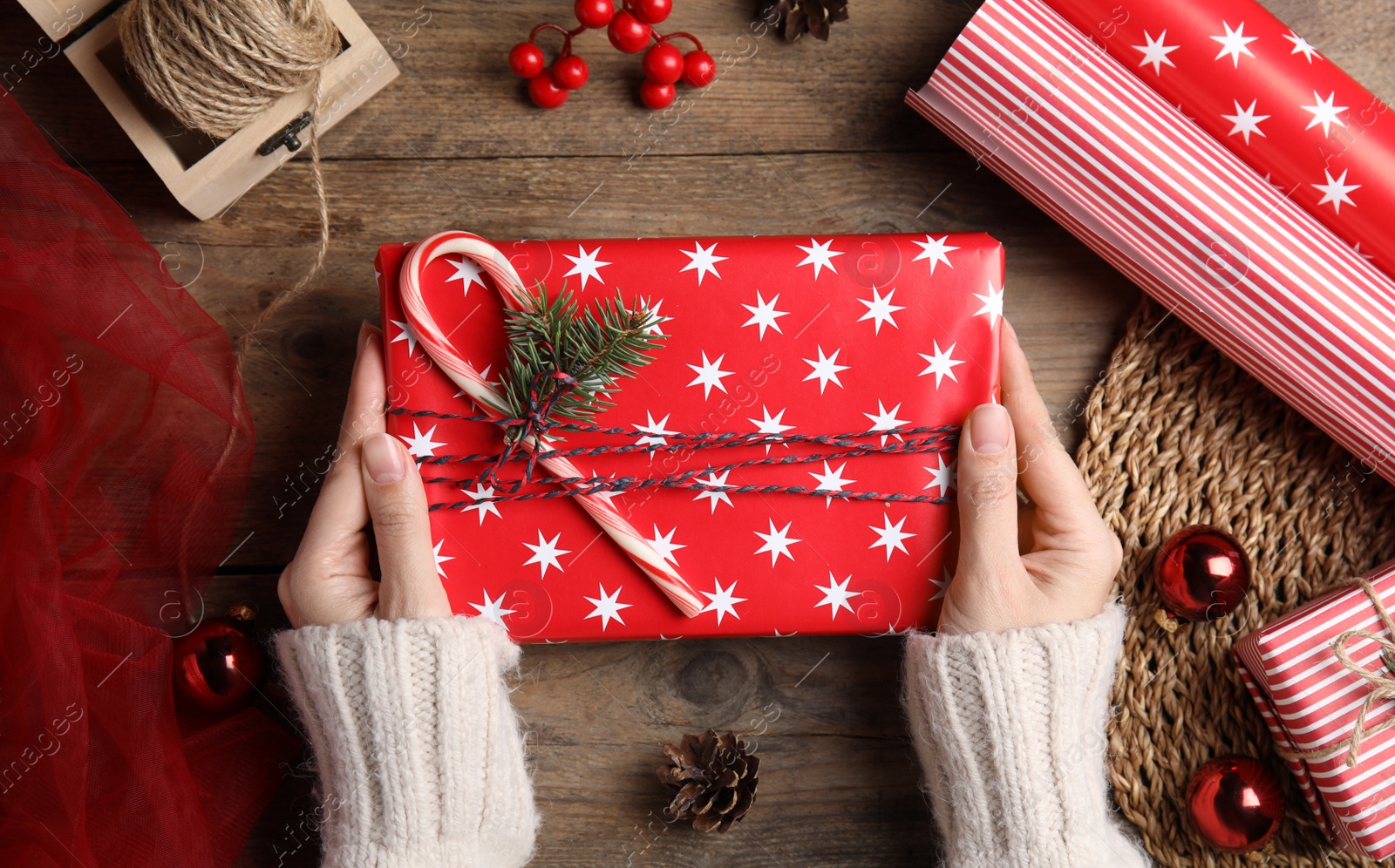 Photo of Woman with gift box at wooden table, top view