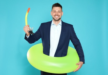 Funny businessman with bright inflatable ring on blue background