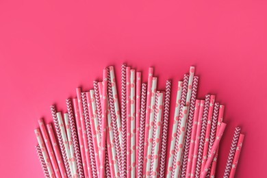 Many paper drinking straws on pink background, flat lay