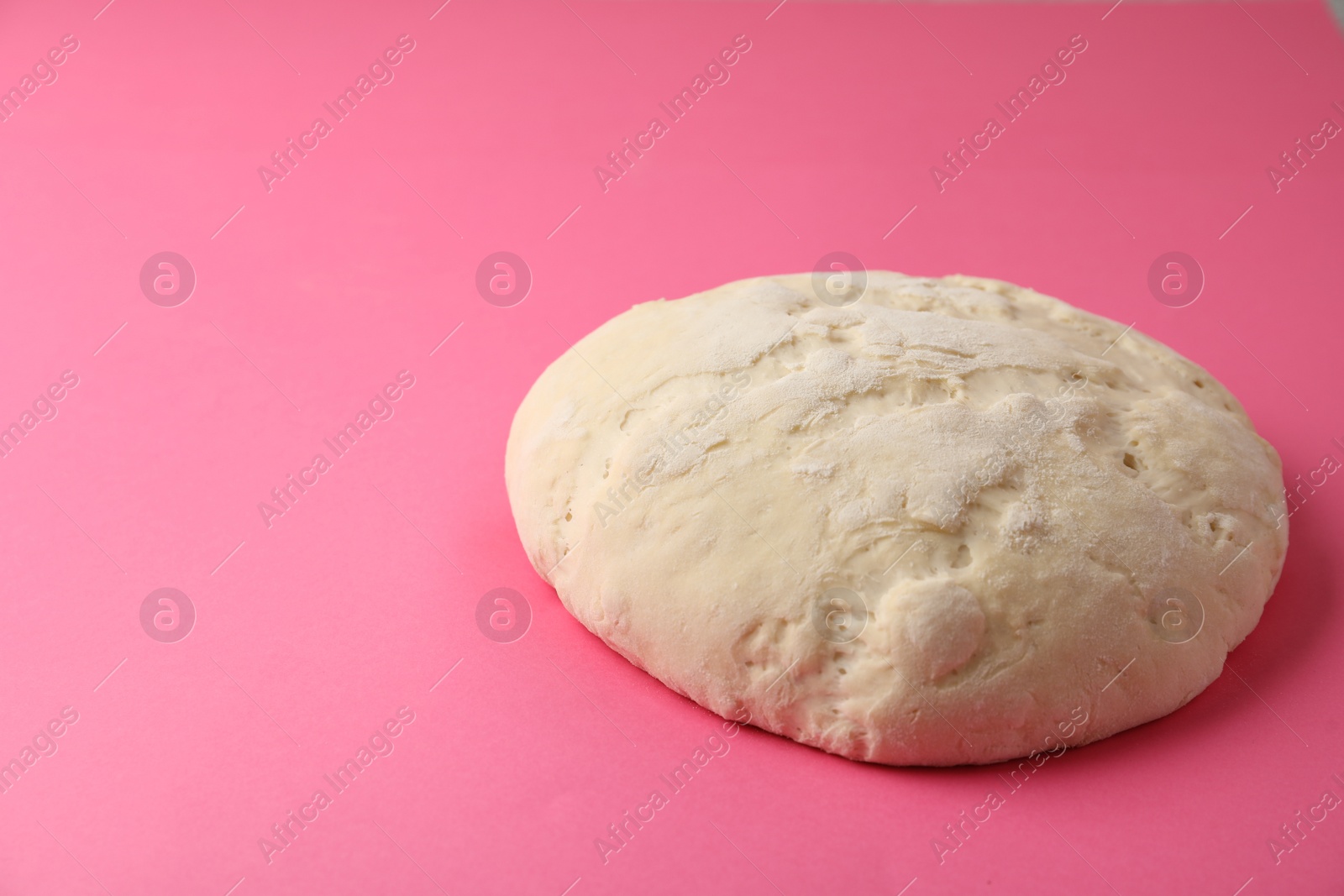 Photo of Raw dough for pastries on pink background. Space for text