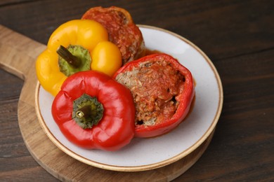 Photo of Delicious stuffed bell peppers served on wooden table