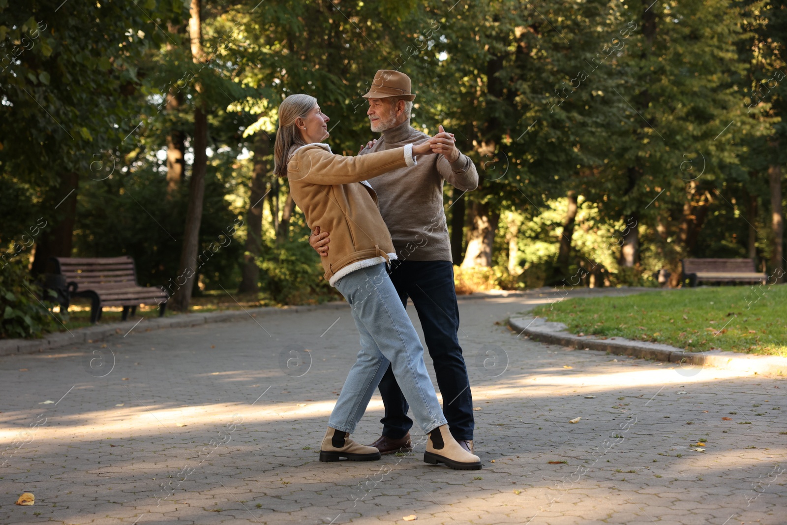 Photo of Affectionate senior couple dancing together in park. Romantic date