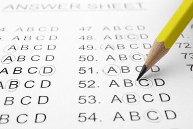 Filling answer sheet with pencil, closeup view