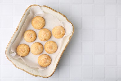 Photo of Tasty sweet sugar cookies in baking dish on white tiled table, top view. Space for text