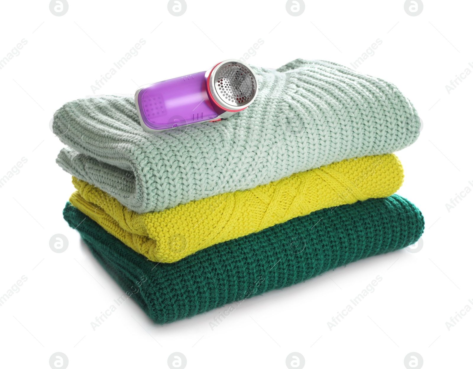 Photo of Modern fabric shaver and woolen clothes on white background