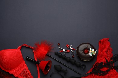 Photo of Flat lay composition with sex toys on black background. Space for text