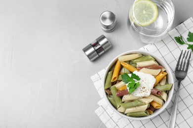 Photo of Delicious pasta with sour cream served on light grey table, flat lay. Space for text