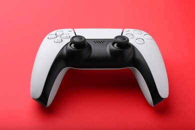 Photo of One wireless game controller on red background