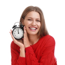 Happy young woman with alarm clock on white background. Christmas time