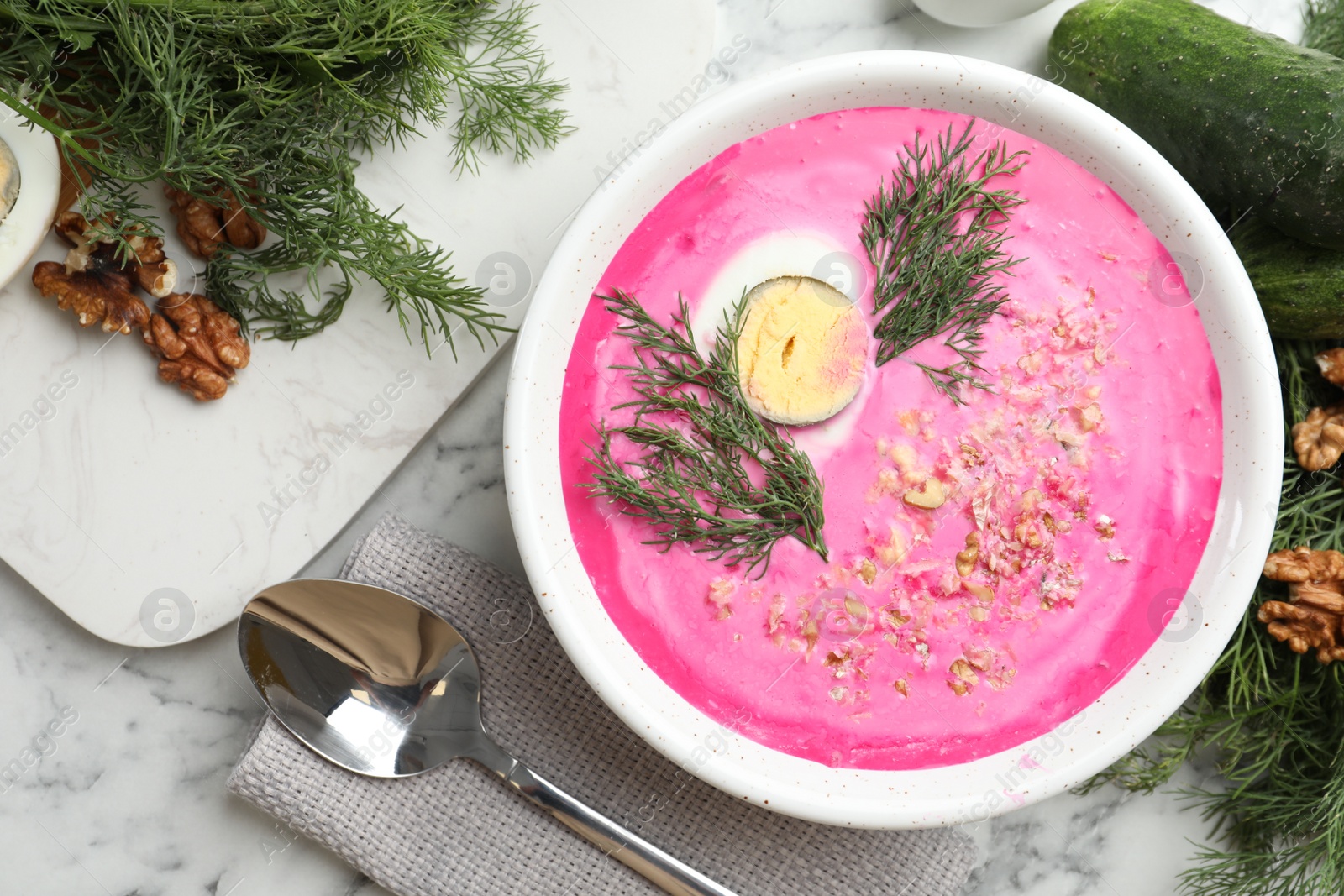 Photo of Delicious cold summer beet soup on white marble table, flat lay