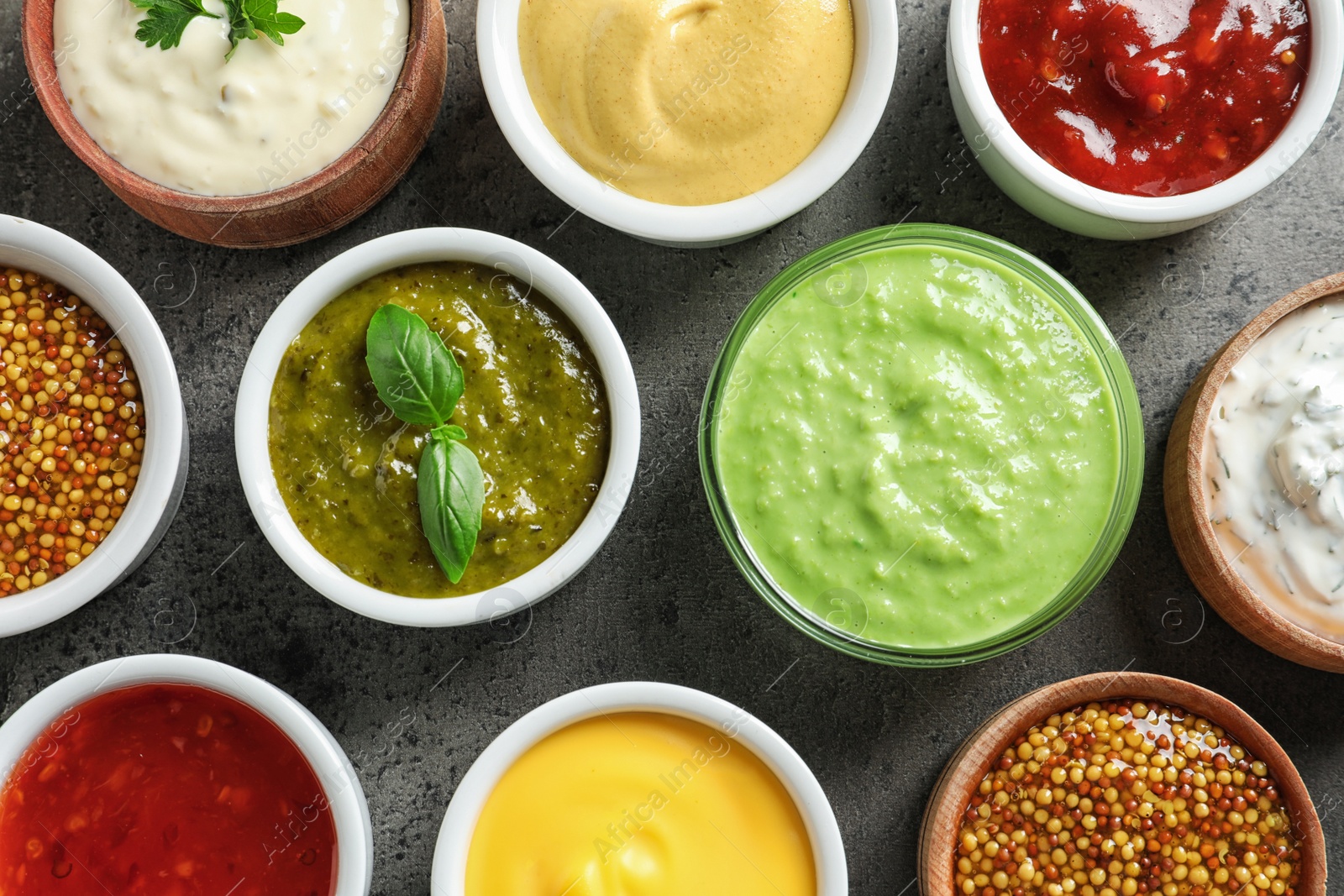 Photo of Set of different delicious sauces on grey table, top view