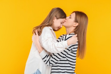 Photo of Portrait of mother and her cute daughter on orange background