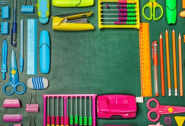 Photo of Flat lay composition with different school stationery on chalkboard surface