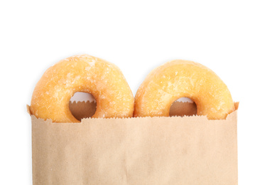 Delicious donuts in paper bag on white background, top view