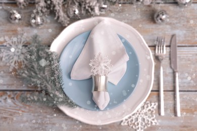 Image of Christmas place setting for festive dinner on wooden table, flat lay. Bokeh effect
