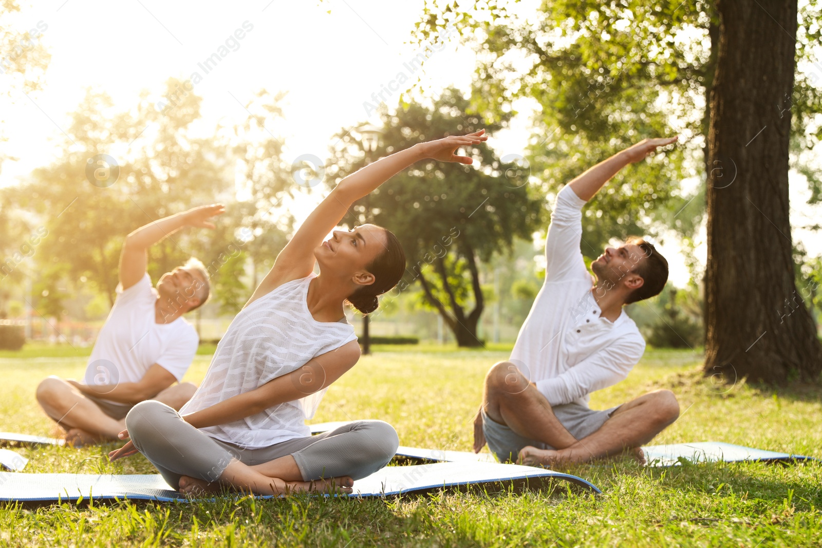 Photo of People practicing yoga in park at morning