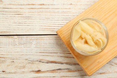 Pickled ginger in bowl on white wooden table, top view. Space for text