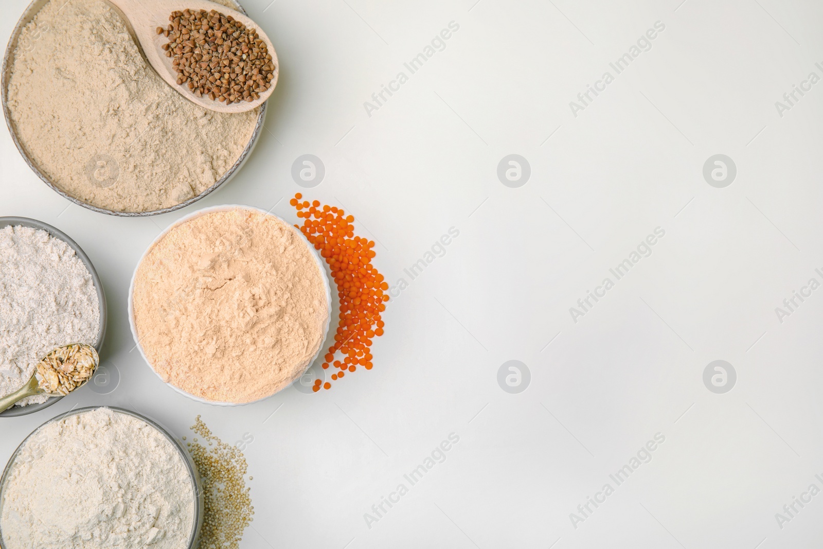 Photo of Different types of flour on white background, top view. Space for text