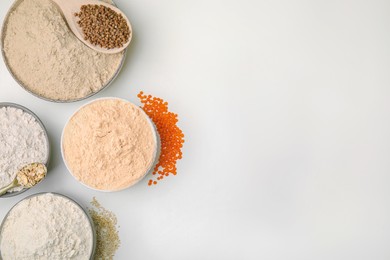 Photo of Different types of flour on white background, top view. Space for text