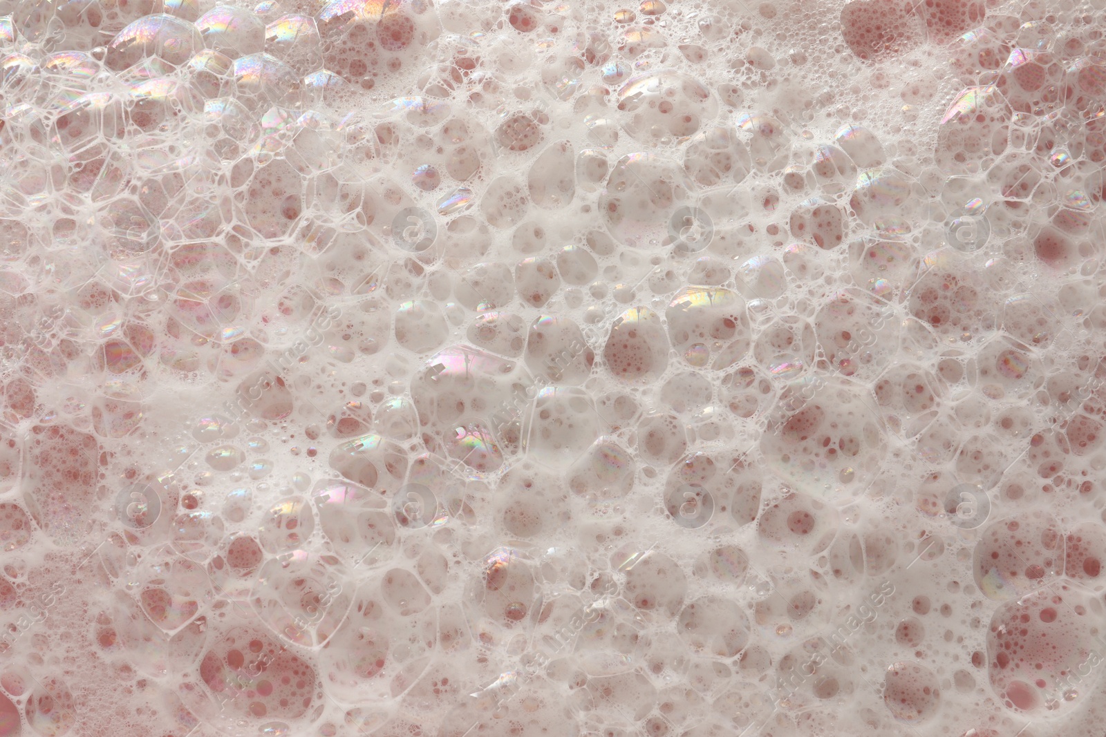 Photo of White washing foam on pale pink background, top view